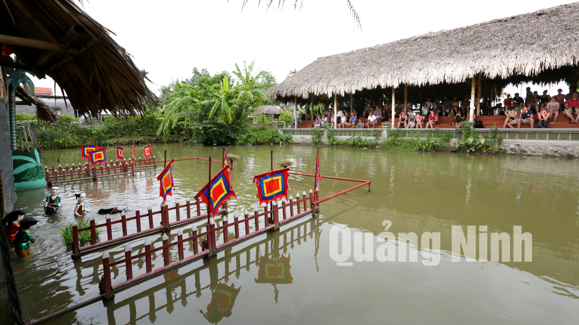 Du khách xem biểu diễn múa rối nước khi đến tham quan làng quê Yên Đức (7-2015). Ảnh: Khánh Giang