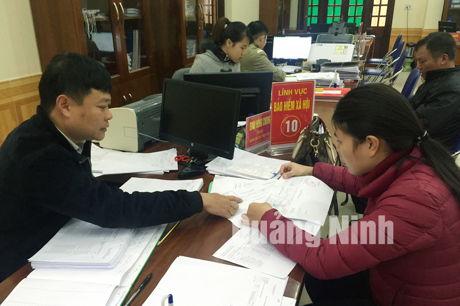Cán bộ Trung tâm Hành chính công huyện Tiên Yên hướng dẫn người dân thực hiện thủ tục hành chính (1-2018). Ảnh: Hà Chi