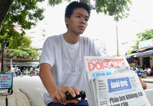 Bán báo dạo trên chiếc xe đạp cũ là công việc mỗi buổi sáng của Nguyễn Quốc Huy. Ảnh: Văn Nguyễn.