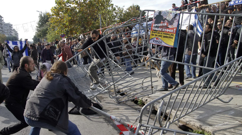 Người biểu tình Hi Lạp giật đổ hàng rào cảnh sát dựng lên trong cuộc biểu tình chống chính sách thắt lưng buộc bụng ở thành phố Thessaloniki - Ảnh: Reuters