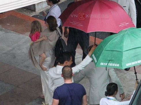 Angelina Jolie bế con gái út Vivienne từ ôtô vào phòng chờ sân bay Tây Sơn Nhất chiều 11/11. Trong khi đó, Brad Pitt (mặc comple sáng màu) đỡ những đứa con còn lại từ trên xe xuống. Ảnh: Q.N. - Q.H.