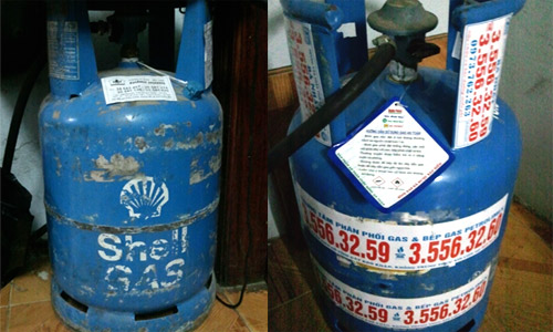 Vỏ bình Shell gas cũ (trái) và bình mới với số điện thoại của đại lý phân phối dán chằng chịt. Ảnh: Ng.Nga
