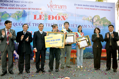 Các đồng chí lãnh đạo ngành du lịch, tỉnh Quảng Ninh chụp ảnh lưu niệm với 3 vị khách du lịch quốc tế thứ 5.999.999, 6.000.000 và 6.000.001