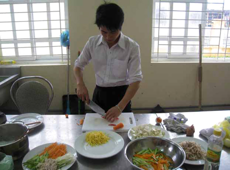 Hoàng Văn Tuyển, sinh viên năm thứ 3, Khoa Khách sạn nhà hàng, Trường Cao đẳng Văn hóa - Nghệ thuật và Du lịch Hạ Long đang làm phụ bếp tại một nhà hàng.