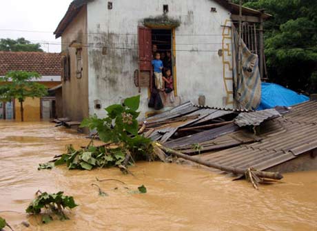 Trong cơn bão số 9 năm 2009, vùng Tân Thành - Hữu Lộc (Tân Ninh, Quảng Ninh, Quảng Bình) bị lũ cô lập hoàn toàn. Nhiều người dân cưu mang nhau trong ngôi nhà nhỏ. Ảnh: Xuân Quang.
