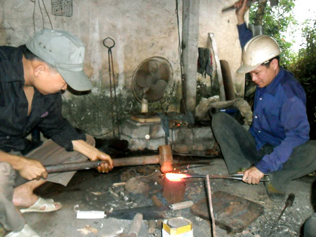Anh Nguyễn Văn Trường (bên phải) cùng thợ phụ đang làm việc.