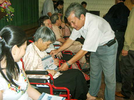 Đại diện Hội Bảo trợ Người tàn tật và Trẻ mồ côi Quảng Ninh tặng xe lăn cho người khuyết tật ở Cẩm Phả.