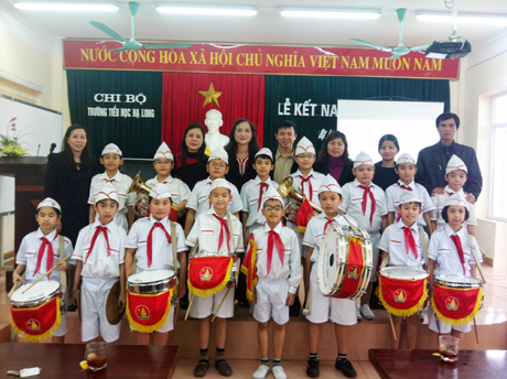 Thầy giáo Nguyễn Hữu Hùng (đứng sau, ngoài cùng bên phải) cùng các đồng nghiệp ở Cung VHTN QN chụp ảnh lưu niệm với các em thiếu nhi trong Đội nghi thức của Trường Tiểu học Hạ Long.