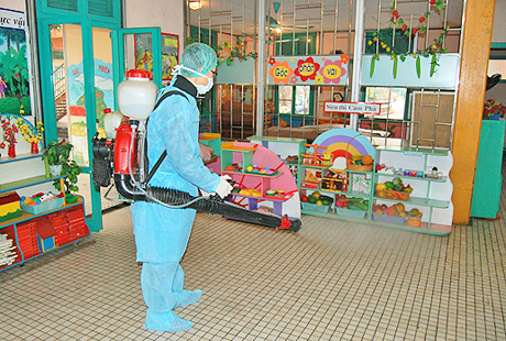Cán bộ Trung tâm Y tế Cẩm Phả phun khử khuẩn môi trường tại các lớp học ở Trường Mầm non Hoa Sen để phòng, chống dịch bệnh.