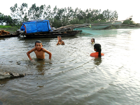 Những ngày hè nóng bức rất nhiều trẻ em ra sông, lạch để tắm. Trong ảnh: Trẻ em tắm tại Cống 5 cửa, xã Sông Khoai, TX Quảng Yên. (Ảnh chụp ngày 14-5-2012).