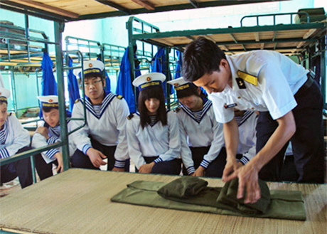Hướng dẫn học viên gấp nội vụ trong chương trình học kỳ quân đội năm 2011 tại Lữ đoàn 147 hải quân.  (Ảnh: TL)