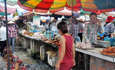 Thức ăn sống, chín ở chợ Trung tâm huyện Hải Hà bày bán xen kẽ, không che đậy.