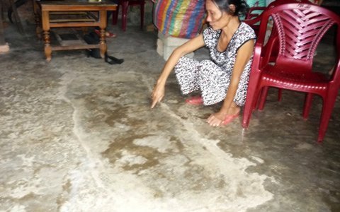Bà T. chỉ tay lên dấu vết cái huyệt giữa nhà mà trước đây chồng đào đòi chôn sống mình.