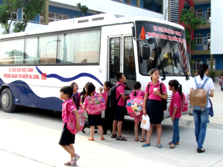 Các em học sinh thích thú đi xe đưa đón của trường (Ảnh tại trường TH-THCS-THPT Văn Lang).