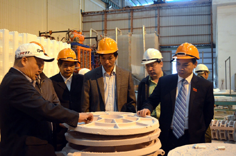 Phó Chủ tịch UBND tỉnh Đặng Huy Hậu (đầu tiên, bên phải) cùng đại diện một số ngành của tỉnh tham quan sản phẩm khuôn xốp định hình trong xây dựng của Xí nghiệp cơ khí Quang Trung.
