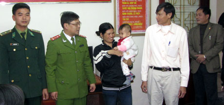 Công an TP Móng Cái trao trả bé Dương Hoàng Anh cho chị Lê Thị Long (mẹ cháu Anh) trước sự chứng kiên của các cơ quan chức năng.