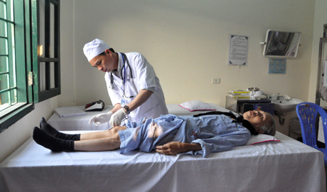 Bác sĩ Khoa Y học cổ truyền (Bệnh viện Đa khoa Hoành Bồ) thăm khám cho bệnh nhân nghèo Phạm Thị Thuận, thôn Khe Mực, xã Tân Dân, Hoành Bồ.
