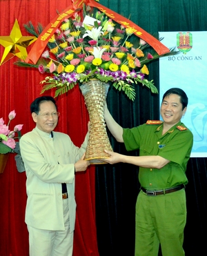 Đại tá Đỗ Văn Lực, Phó Giám đốc Công an tỉnh (bên phải), tặng hoa chúc mừng trại sáng tác. 