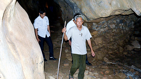 Ông Lục Văn Lường, Trưởng ban Mặt trận thôn Hà Lùng, xã Sơn Dương giới thiệu di tích hang Tỉnh uỷ.