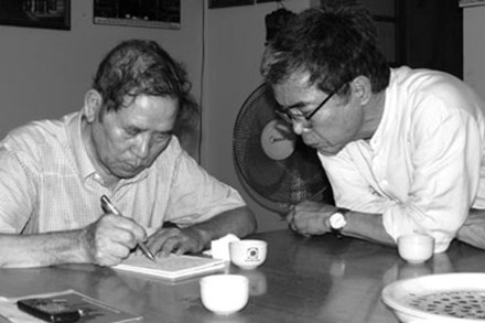 Nhà văn Lê Lựu (trái - đang viết giấy yêu cầu) và nhà văn Trung Trung Đỉnh (ảnh chụp ngày 20.6.2013). Ảnh: Y TRANG