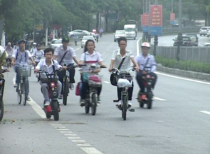 Học sinh đi xe đạp điện thờ ơ với đội mũ bảo hiểm