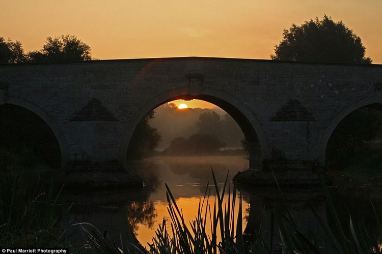  Mặt trời mọc trên cầu Milton Ferry trên sông Nene gần Peterborough, Cambridgeshire. 