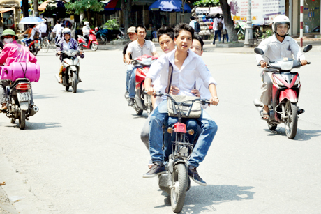 Học sinh đi xe đạp điện chở quá số người quy định, không thực hiện đội MBH. Ảnh chụp gần cổng trường THPT Lương Thế Vinh (TP Cẩm Phả)