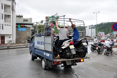 Lực lượng chức năng bố trí xe tải đưa người dân qua cầu để đảm bảo an toàn.