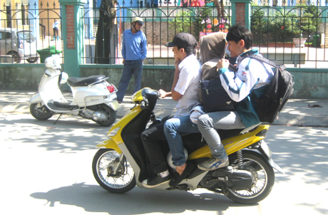 Đi xe máy không đội mũ bảo hiểm, trở quá số người quy định.