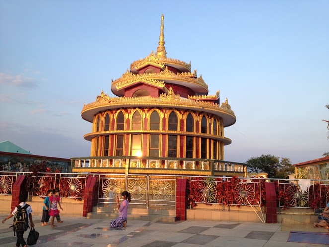 Một ngôi chùa sáng bừng trong ánh hoàng hôn trong quần thể chùa Hòn Đá Vàng, trên đỉnh núi thuộc thị trấn Kyaikto.