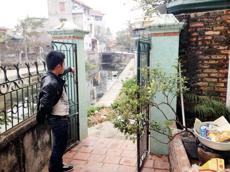 Con trai ông Tiền đang chỉ cho phóng viên ngõ đi của gia đình ông bên mép sông Cầu Chỗ.