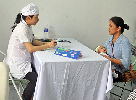 Tư vấn cho người mẹ trước khi tiêm phòng cho trẻ tại Trạm Y tế phường Cao Xanh (TP Hạ Long).