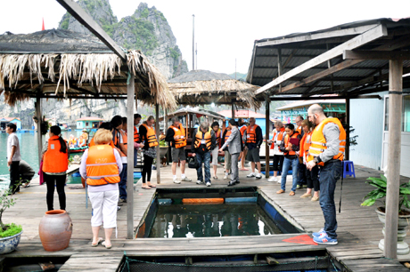 Du khách nước ngoài tham quan làng chài Vung Viêng trên Vịnh Hạ Long.