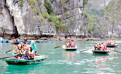 Khách du lịch chèo thuyền nan tham quan làng chài Vung Viêng trên Vịnh Hạ Long.