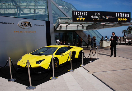 Lamborghini Aventador màu vàng nằm ở lối vào triển lãm.