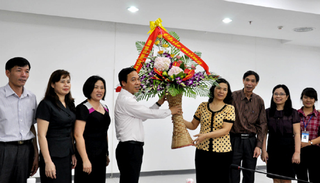 Đồng chí Đặng Huy Hậu, Phó Chủ tịch UBND tỉnh tặng hoa chúc mừng cán bộ, nhân viên Thư viện tỉnh.