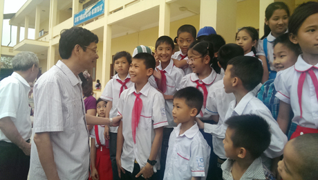 Đồng chí Chủ tịch UBND tỉnh Nguyễn Văn Đọc trò chuyện với các cháu học sinh Trường Tiểu học Thị trấn Cái Rồng (Vân Đồn).