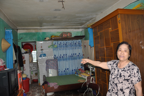 Bà Trần Thị Bích đang chỉ cho chúng tôi về tình trạng căn hộ đã xuống cấp của mình