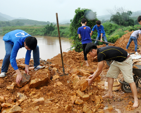 Sinh viên Trường Cao đẳng công nghiệp và xây dựng Uông Bí khuân đất, đá đắp lề đường.