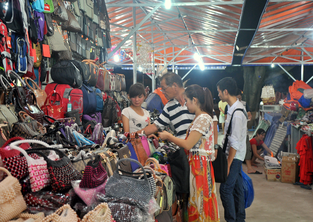 Khách du lịch đến thăm quan và mua sắm tại chợ.