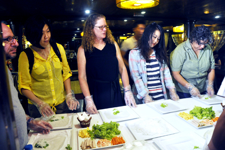 Các thành viên trong đoàn cùng trải nghiệm khi làm món nem cuốn của Việt Nam trên tàu Victorya Cruise.