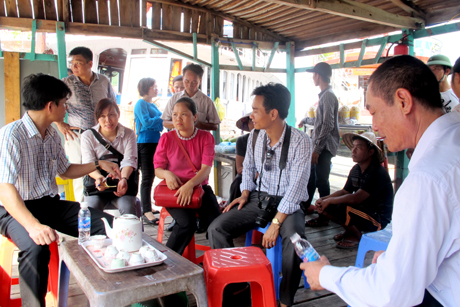 Các thành viên đoàn kiểm tra nghe báo cáo về hoạt động dịch vụ tại làng chài Ba Hang.