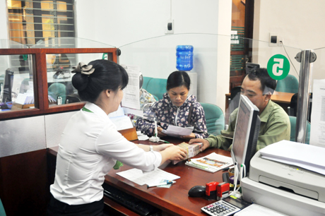 Cán bộ tín dụng Ngân hàng Vietcombank Móng Cái giải quyết thủ tục vay vốn cho người dân.