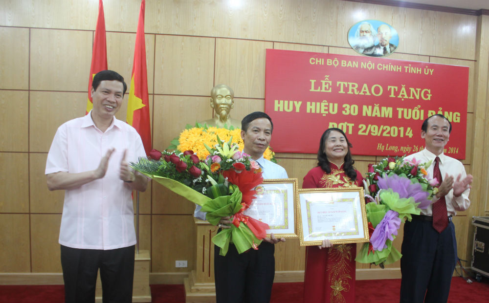 Đồng chí Nguyễn Đức Long, Phó Bí thư Tỉnh ủy, Chủ tịch HĐND tỉnh trao huy hiệu 30 năm tuổi Đảng cho đồng chí Đỗ Vũ Chung và Nguyễn Thị Liễu. 