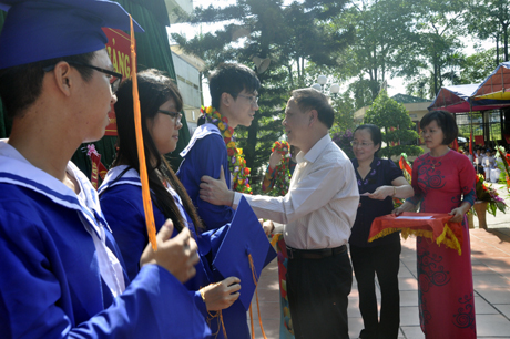 Đồng chí Đỗ Thông, Phó Chủ tịch Thường trực UBND tỉnh trao vòng hoa, quà chúc mừng các em học sinh đỗ đại học của nhà trường tại lễ khai giảng