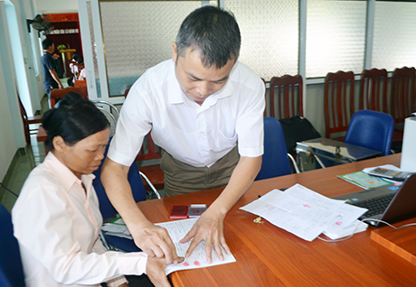 Chị Trần Thị Quý, thôn Ngàn Kheo, xã Hoành Mô, huyện Bình Liêu điểm chỉ vào giấy tờ xác nhận thủ tục