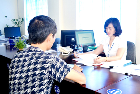Cán bộ BHXH Uông Bí hướng dẫn thủ tục hưởng trợ cấp 1 lần cho NLĐ tại Trung tâm Hành chính công thành phố.