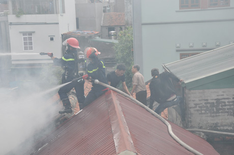 Lính cứu hoả phải trèo lên nóc nhà dân bên cạnh để chữa cháy.