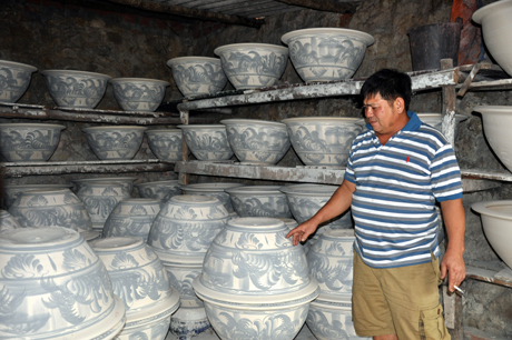 Anh Trần Văn Đạo, một thợ gốm lành nghề ở khu Cầu Đất (xã Đức Chính) đang giới thiệu sản phẩm thô trước khi đưa vào lò nung.