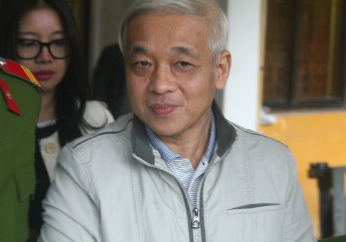 Bầu Kiên bị dẫn giải ra xe thùng sau phiên toà chiều 2/12. Phía sau lưng là vợ bị cáo.